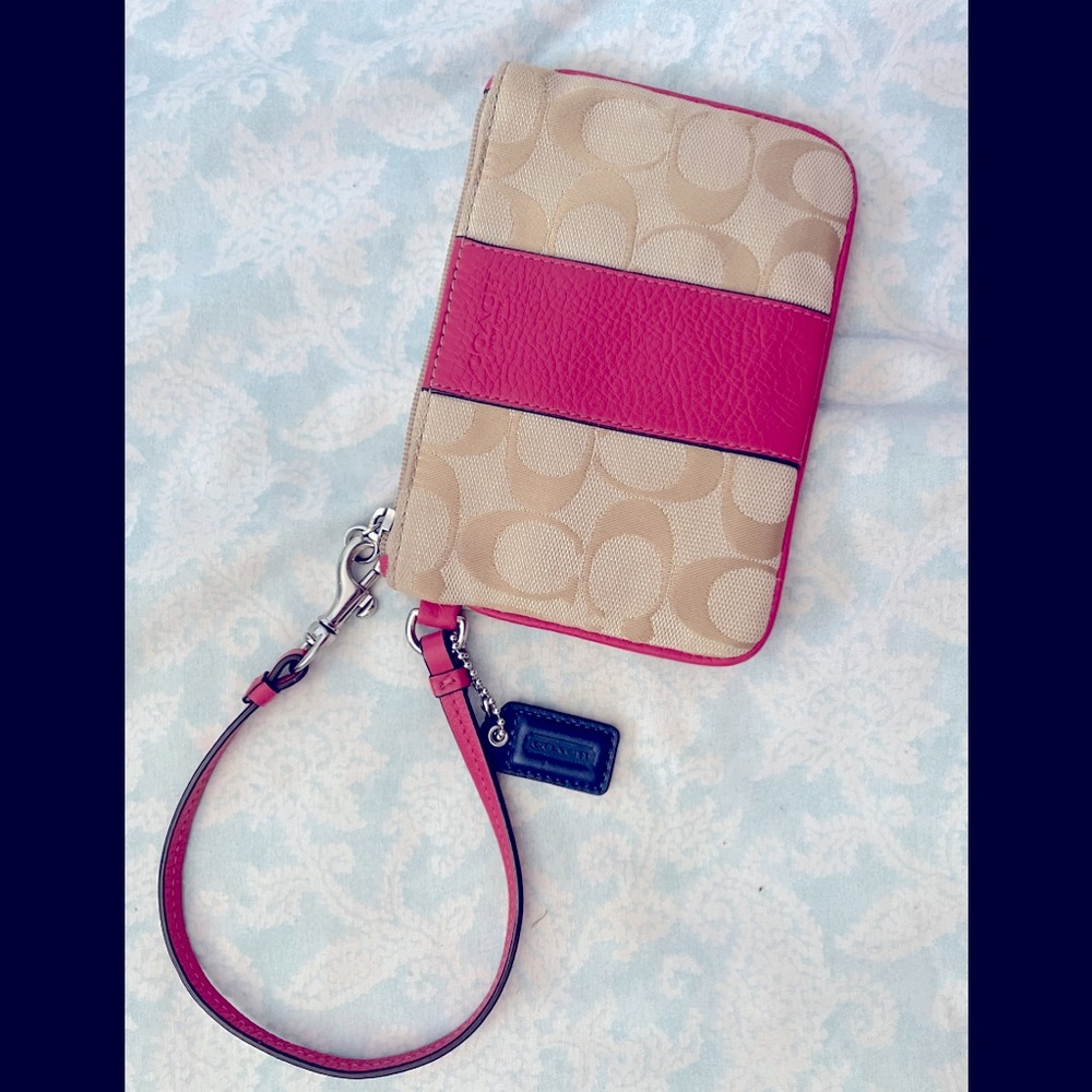 Coach wristlet tan with a fuchsia pink trim.
